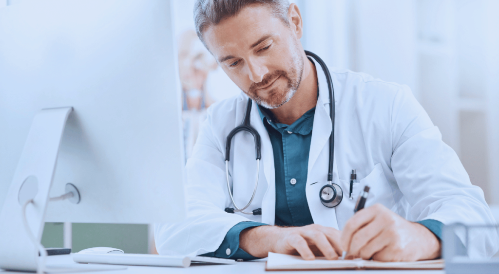 A doctor carefully writes notes on a clipboard, focused and attentive. This represents how VA doctors are well-versed in medical conditions affecting veterans, using their expertise to assess, diagnose, and document issues related to military service.