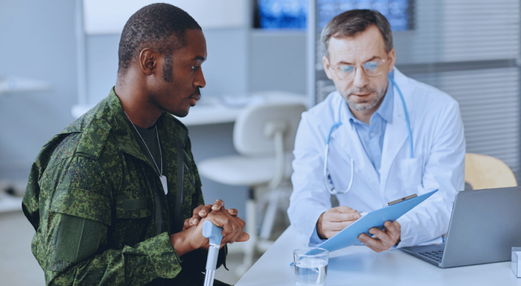 A veteran sits across from a doctor, engaged in conversation. The doctor listens attentively, offering expert insight. This scene highlights how a medical professional’s opinion can play a crucial role in securing VA disability benefits by providing the necessary evidence to support a veteran’s claim.