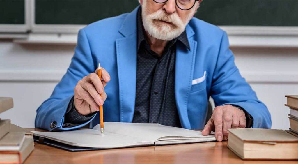 A senior veteran sits with papers spread out, reading carefully and jotting down notes. The focused expression shows determination—this isn’t just paperwork, it’s preparation for something that matters.