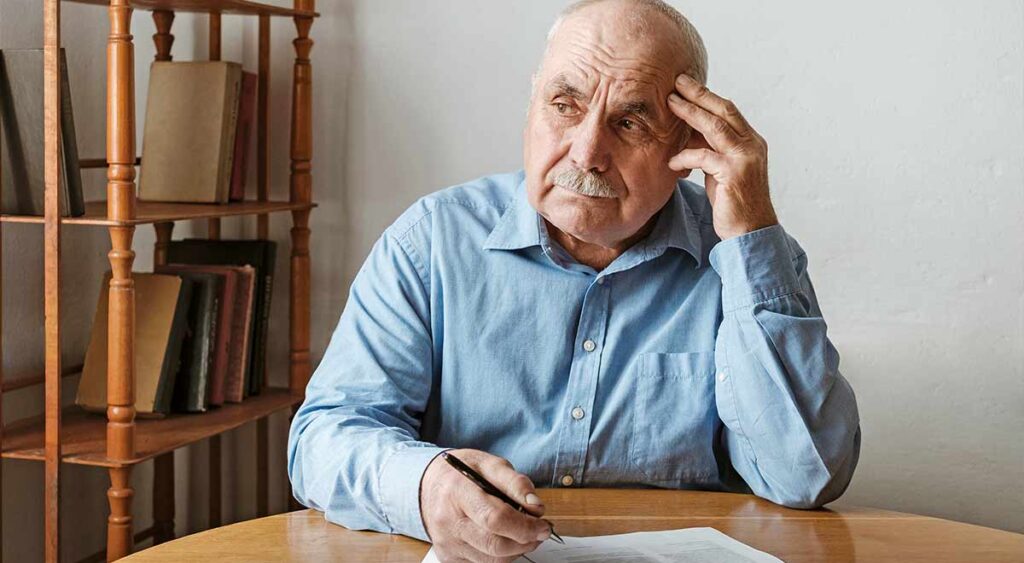 An elderly man completing an exam shows what an Independent Psychological Examination looks like — a key step in evaluating mental health for VA claims.