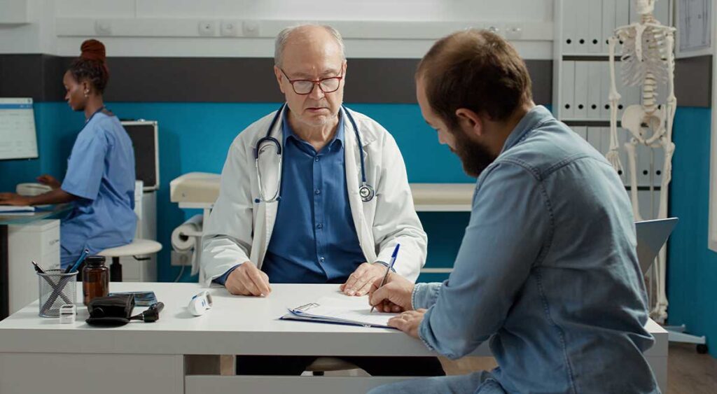 A patient signs important medical documents—steps that may be part of obtaining an Independent Medical Opinion (IMO) or Psychological Evaluation (IPE) for their VA disability claim.