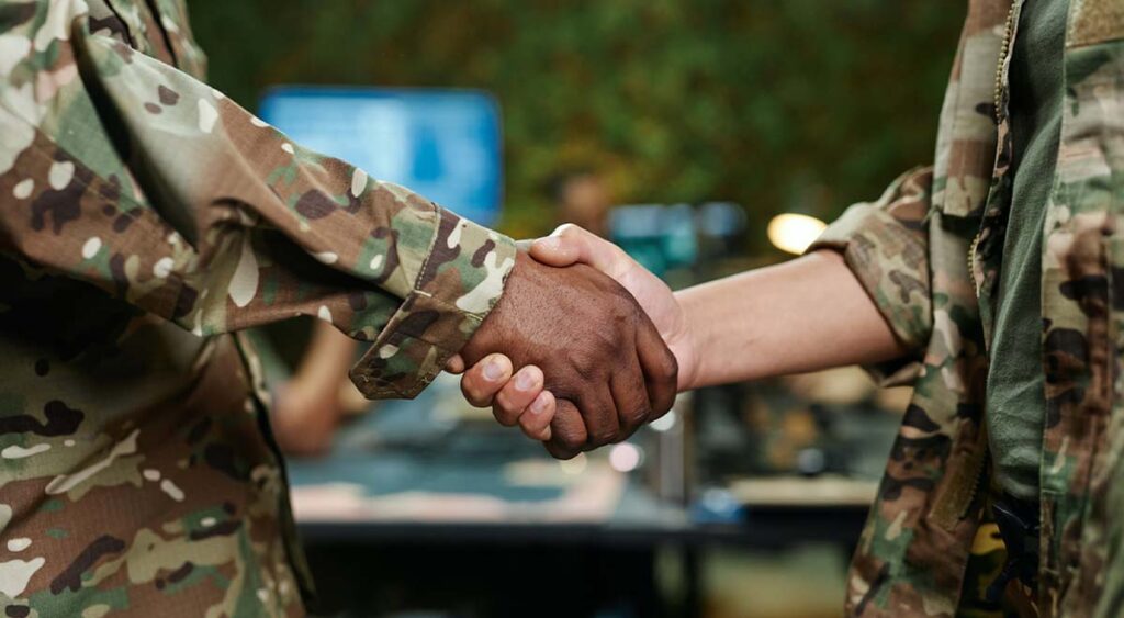 A handshake reflects the need for partnership—VA doctors evaluate, but independent experts like Attain Med Group advocate, helping veterans strengthen their disability claims.